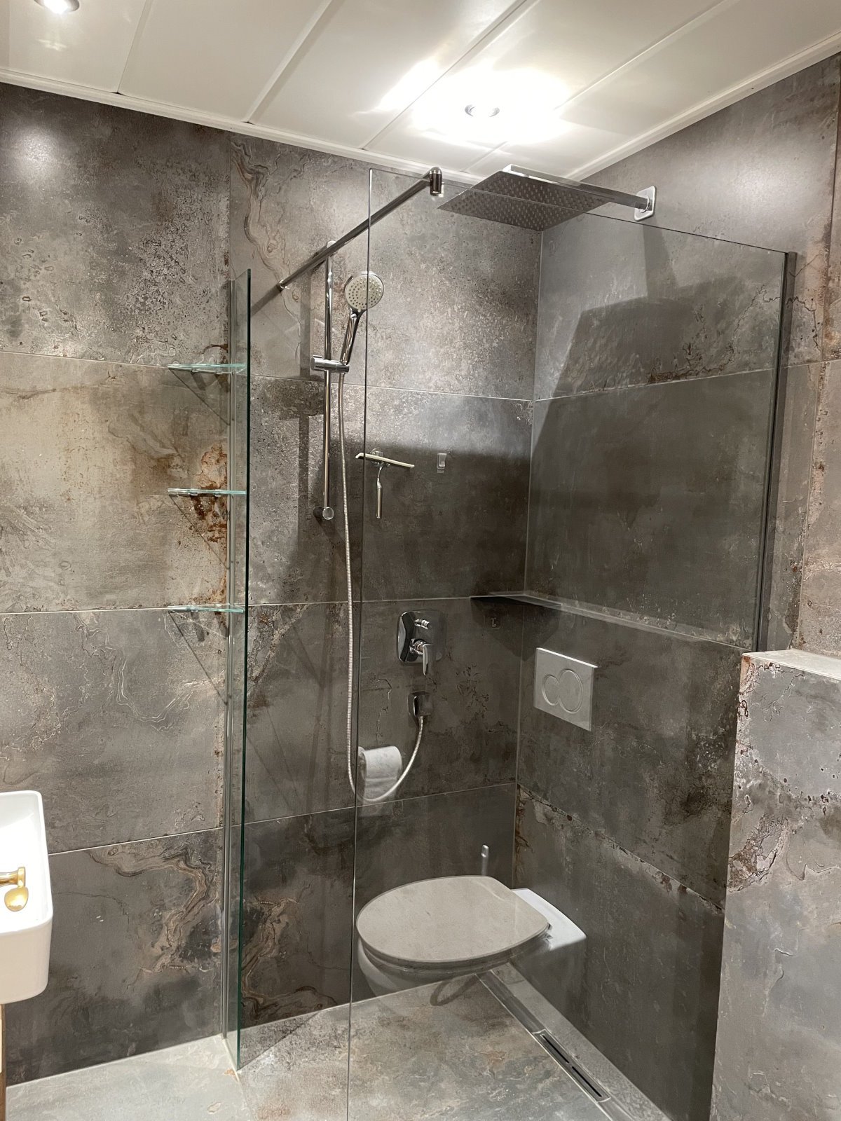 Badezimmer mit großer Glasdusche und WC