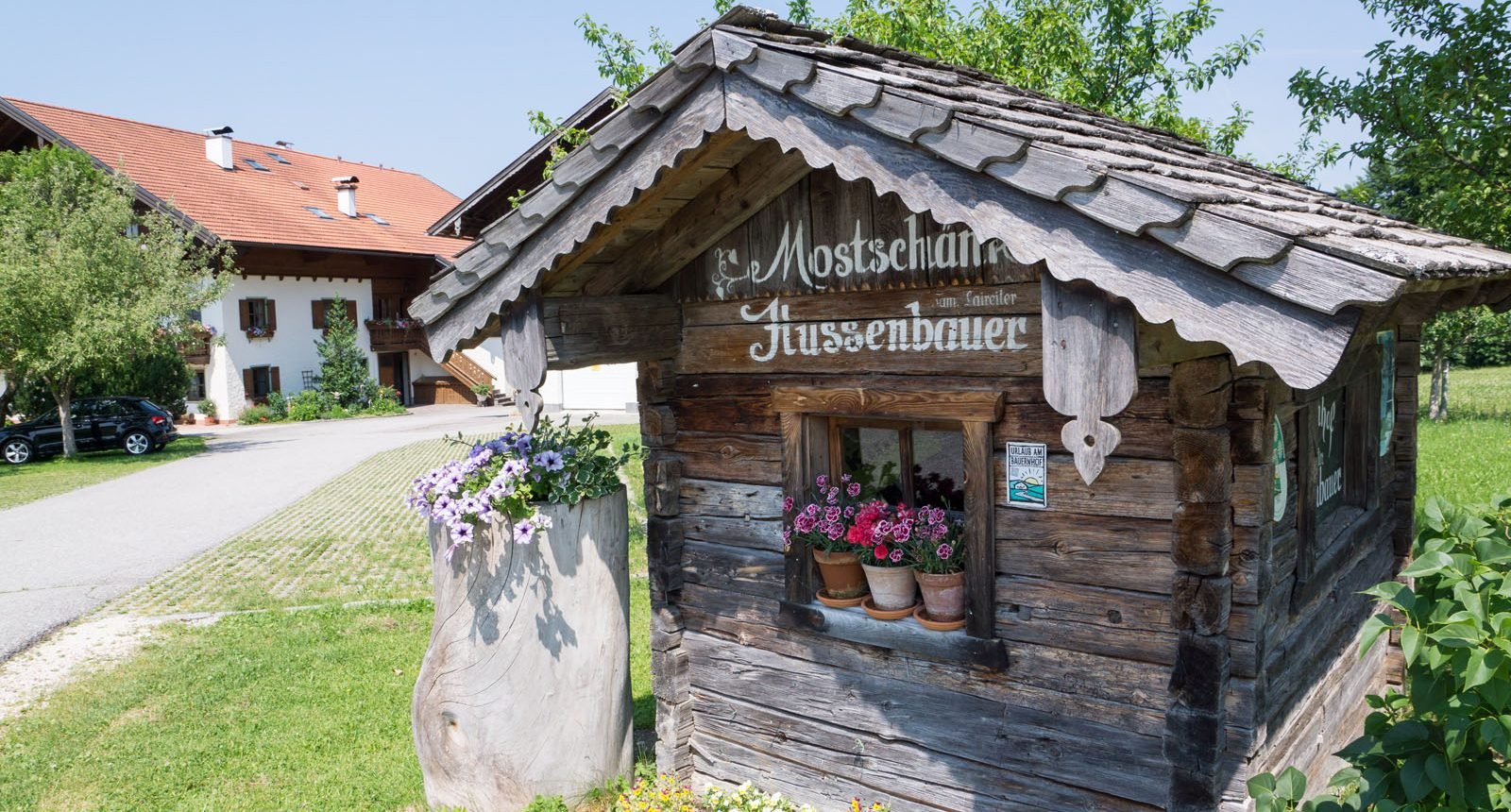 Rustikales Holzhäuschen mit dem Schriftzug Mostschänke Hussenbauer