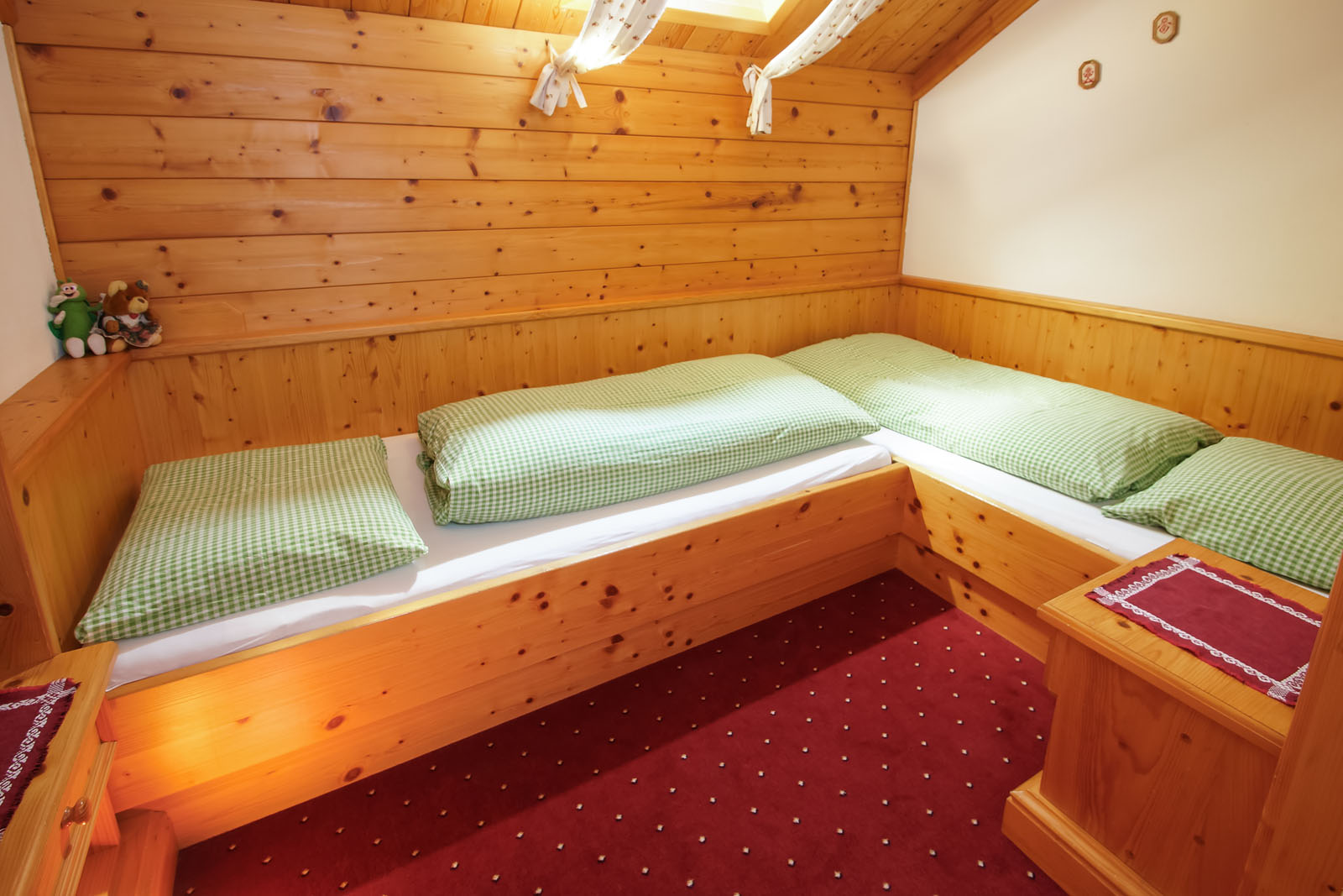 Kinderzimmer mit zwei über Eck eingebauten Holzbetten